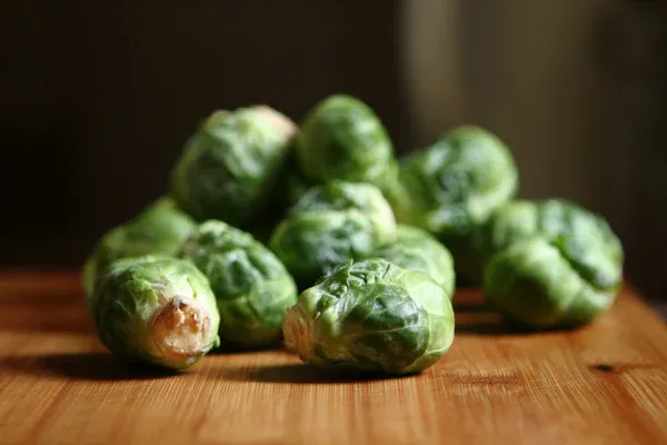 Green leafy Brussels Sprouts for dogs on a wooden cutting board at FurHaven Pet Products